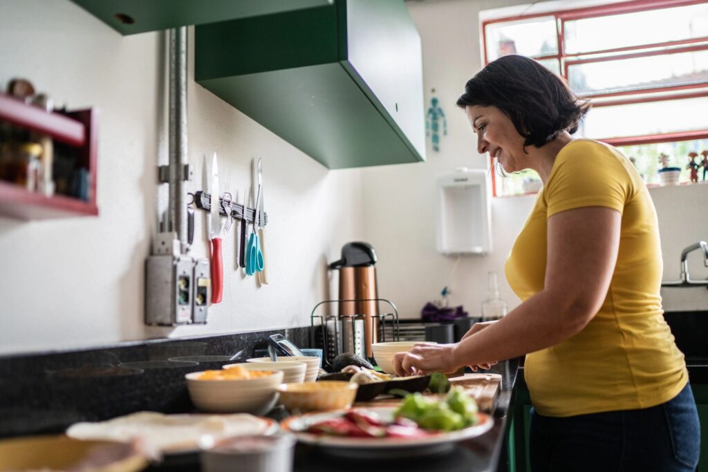 Mature woman chopping food at home