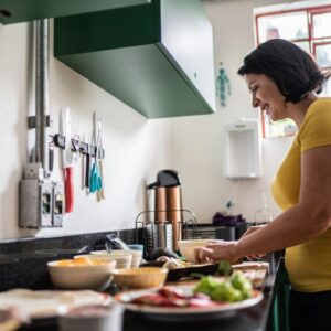 Mature woman chopping food at home