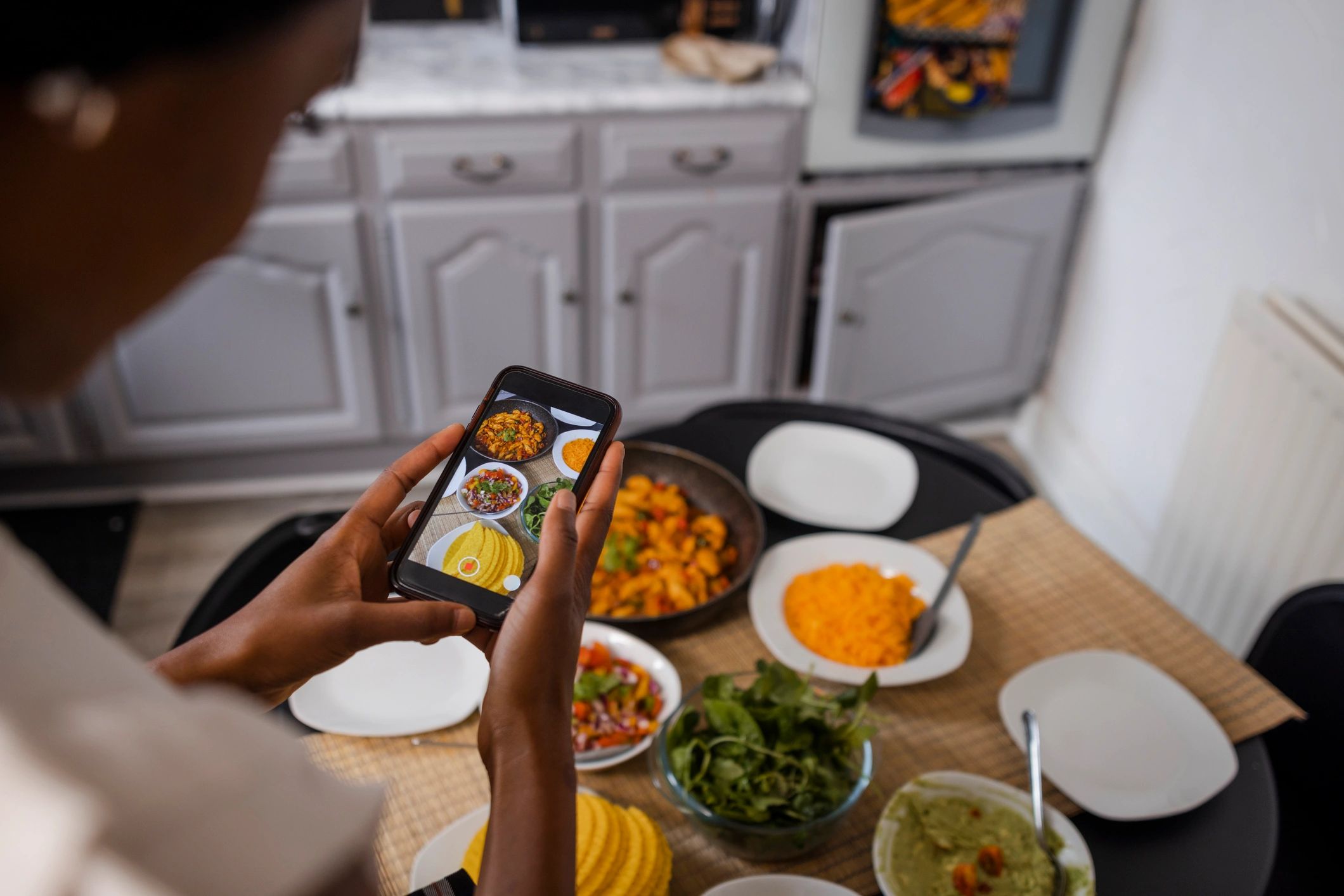 Phone recording a home food creator table setup for livestream content