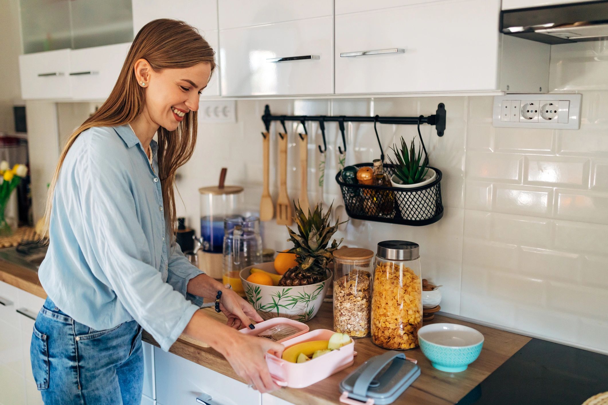 Smiling woman packing lunch in a kitchen