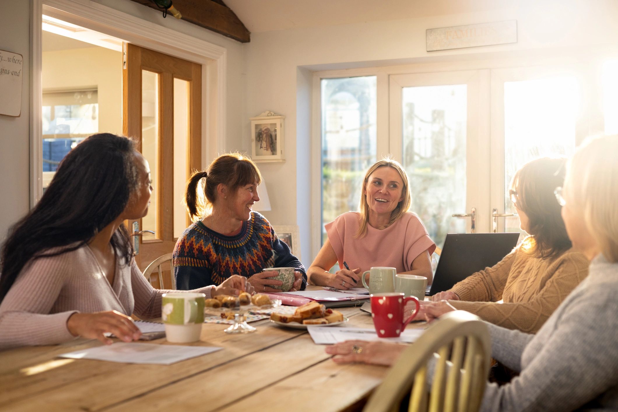 Community gathering around a table with food and drinks
