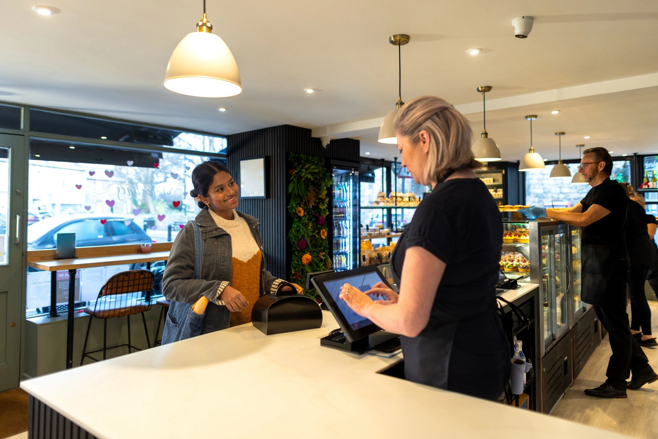 Customer completing a bakery counter transaction
