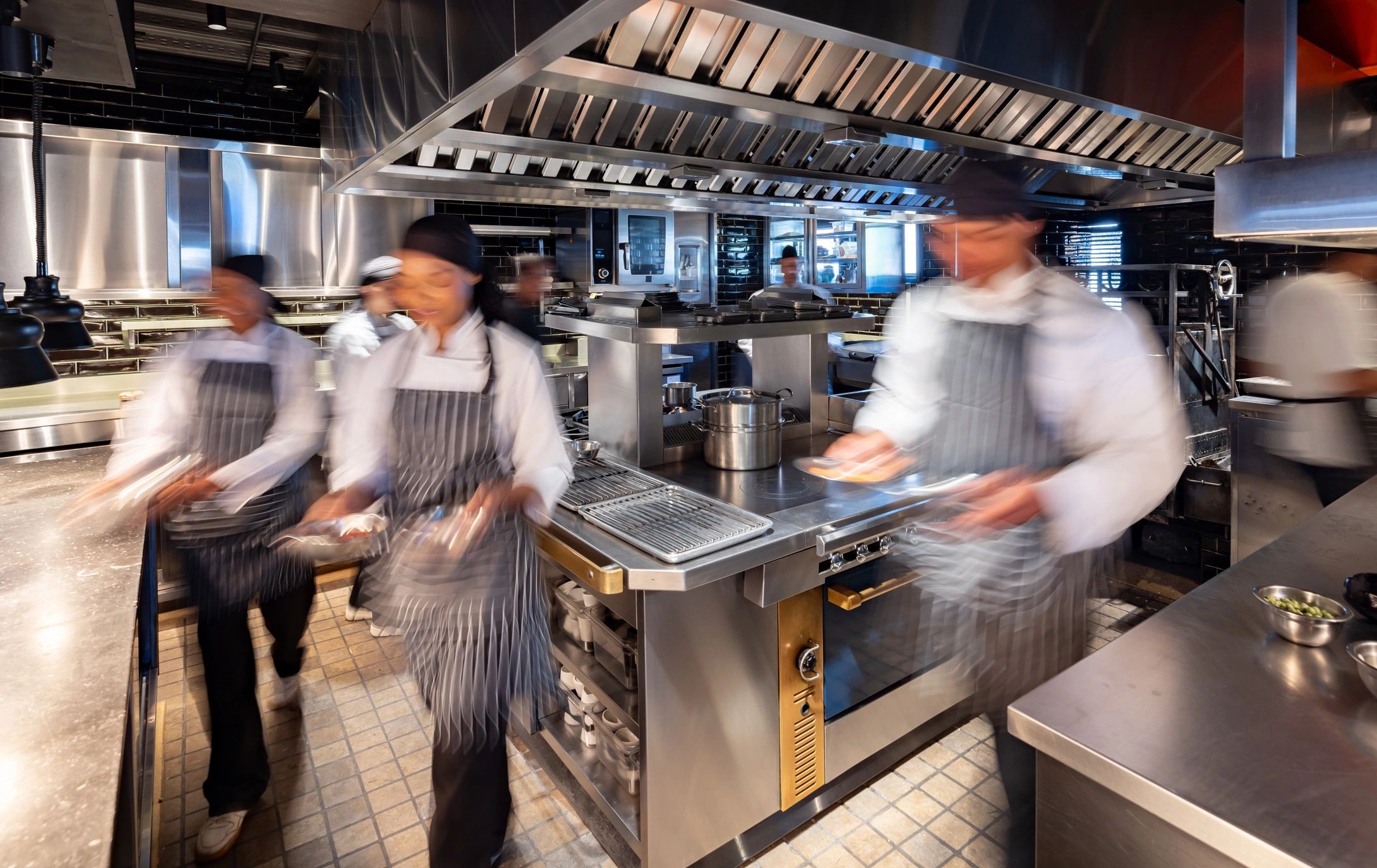 Busy kitchen scene with cooks preparing food