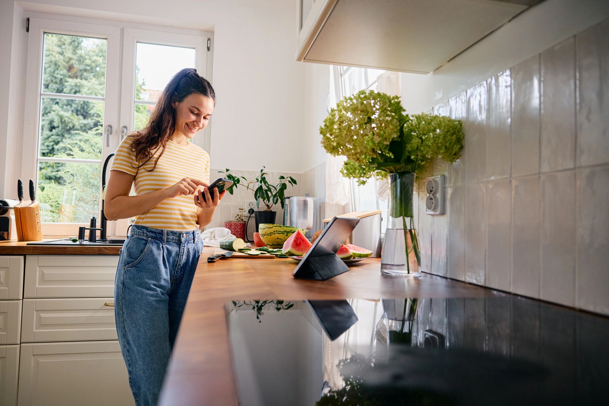 Home cook preparing a meal while checking a recipe in the kitchen
